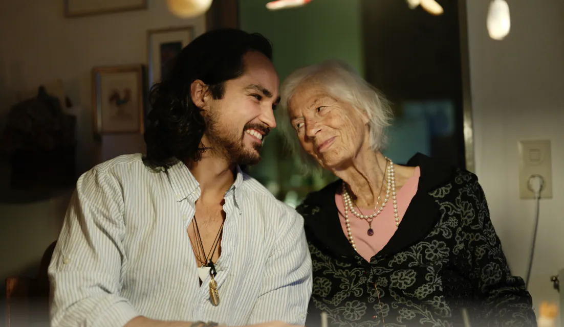 Keno and his grandmother Valerie side by side at a table, smiling